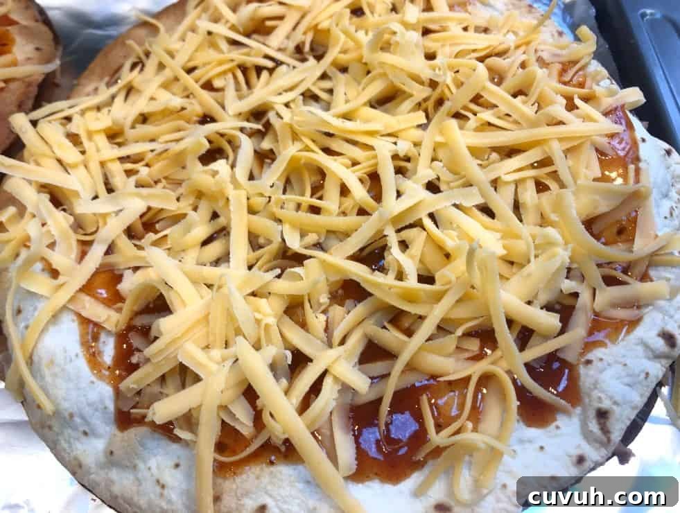 Copycat Taco Bell Mexican Pizza Recipe to Make at Home 8 mexican pizza before cooking with cheese on top.