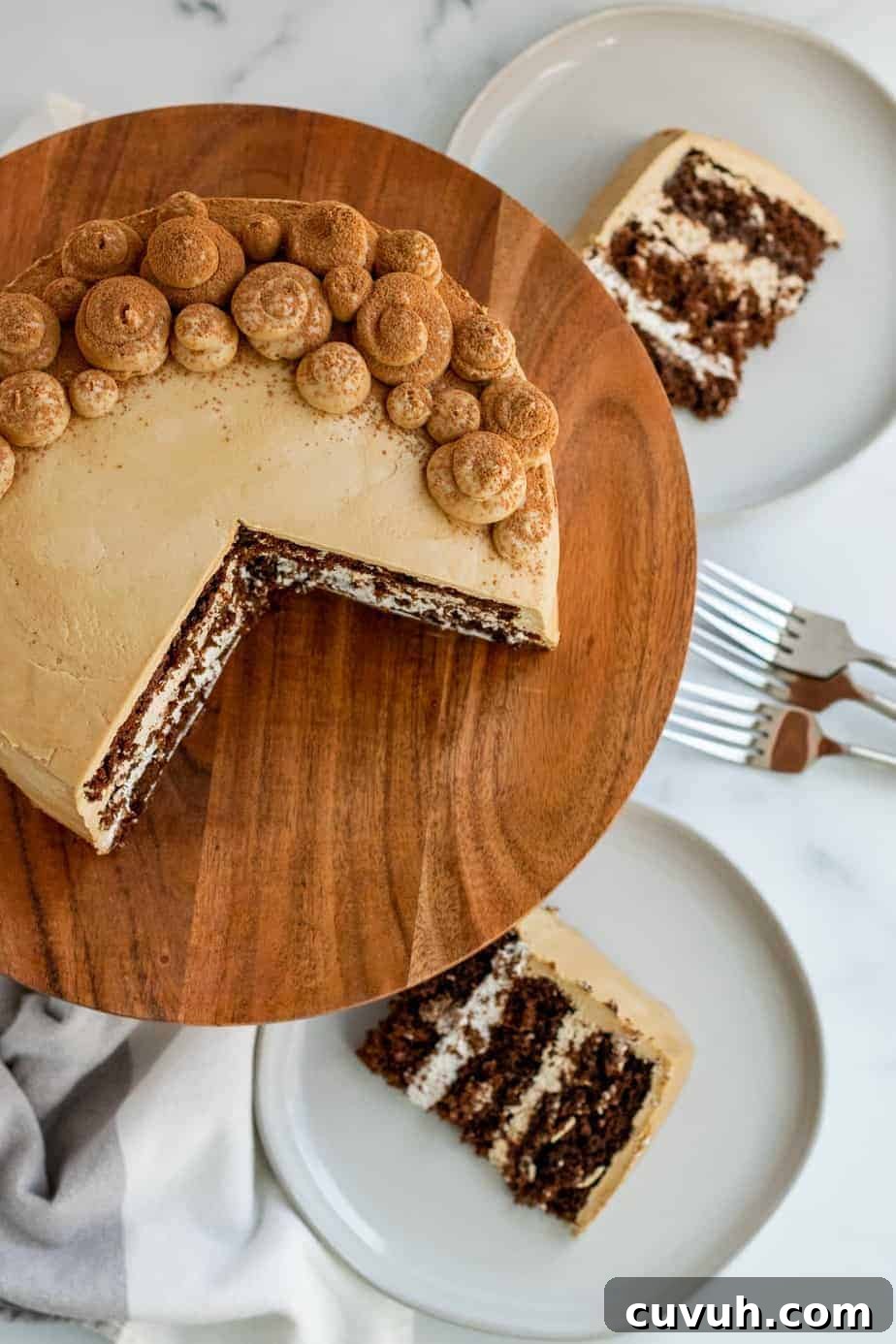 chocolate mocha cake on a wood cake stand with 2 slices of cake on plates