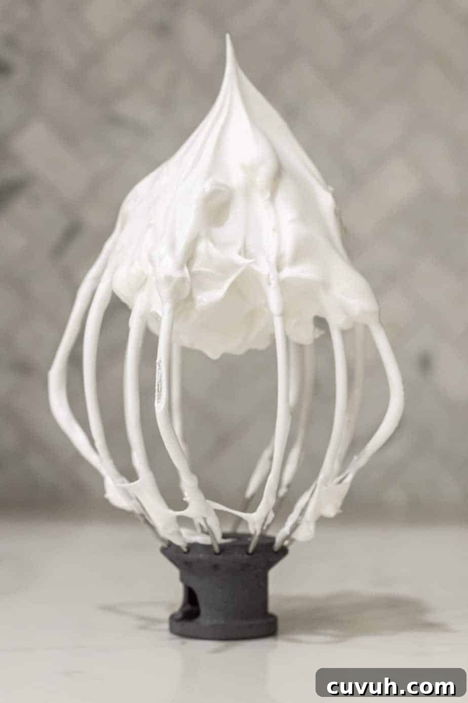 stand mixer whisk with white meringue on whisk