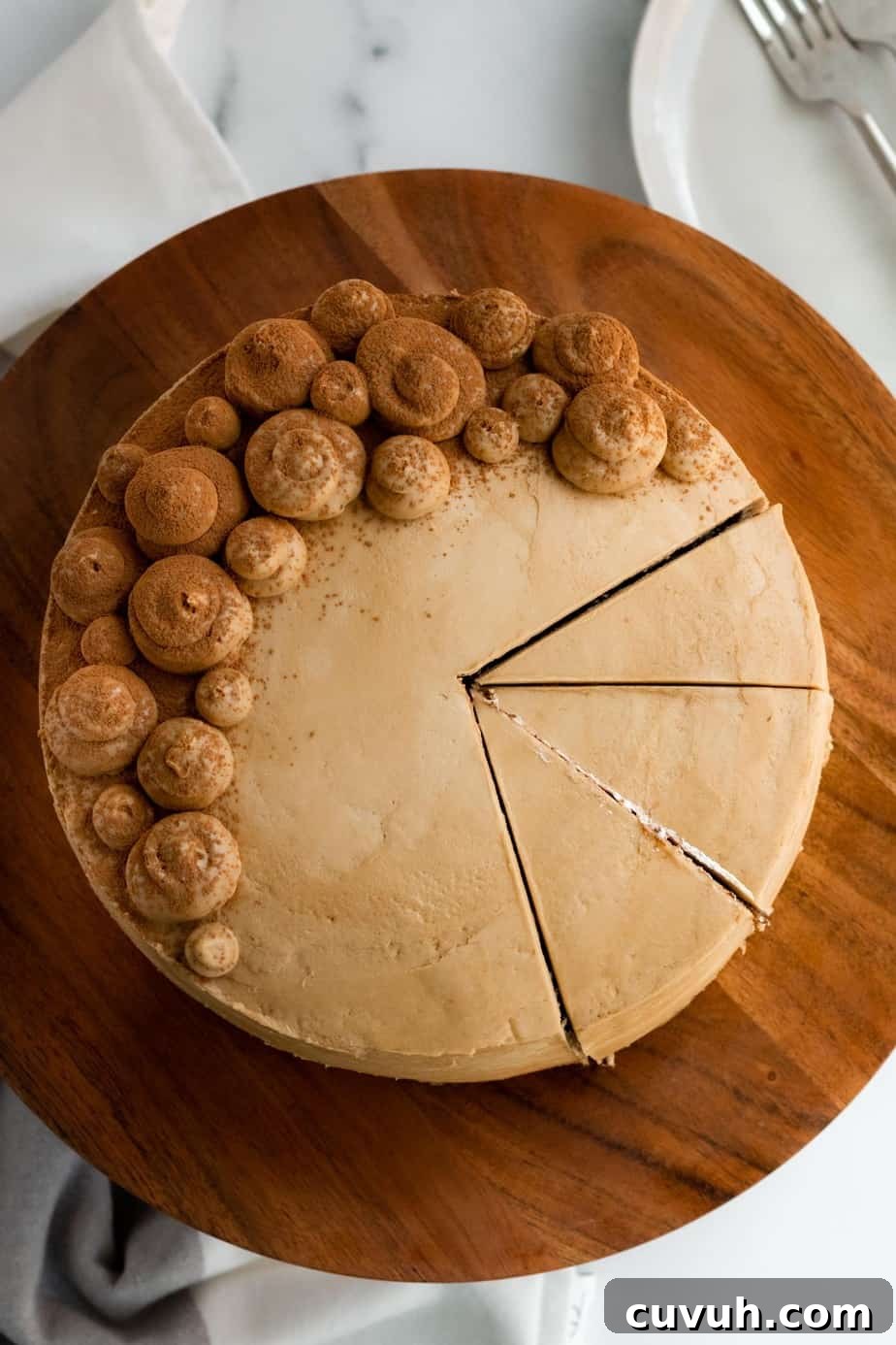 chocolate mocha cake on a wood cake stand with 3 slices cut from the cake