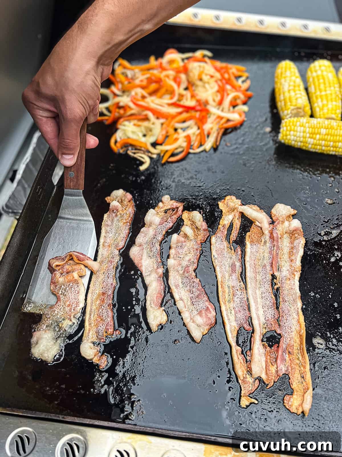 Crispy Bacon on the Blackstone Griddle: Tips for Perfect Results 4 Closeup flipping bacon on Blackstone Griddle