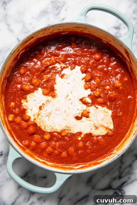 Chickpea Tikka Masala Recipe: Flavorful Vegan Curry in 30 Minutes 7 Coconut milk mixed in with chickpeas and tomato sauce.