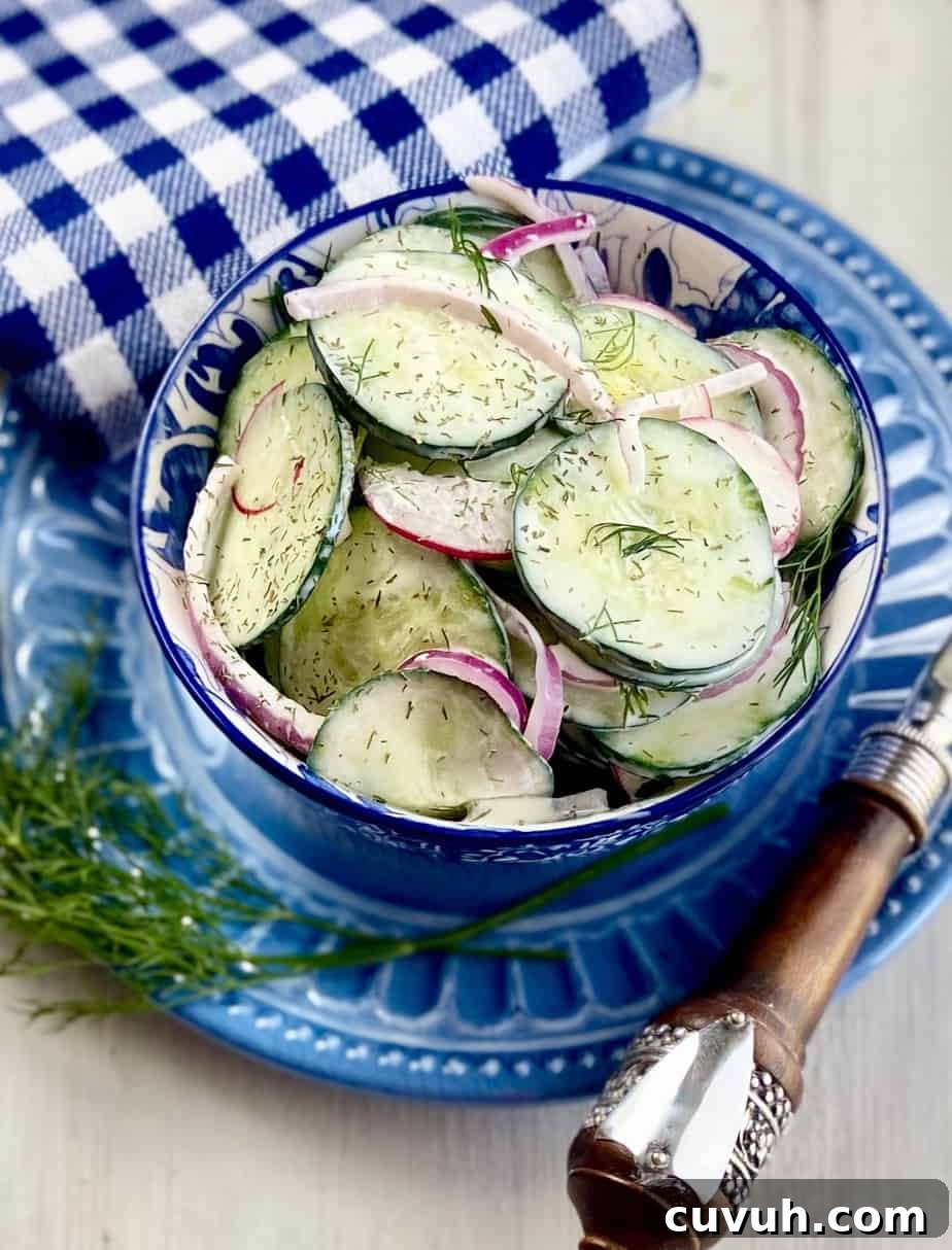 Creamy cucumber salad in a blue and white bowl.