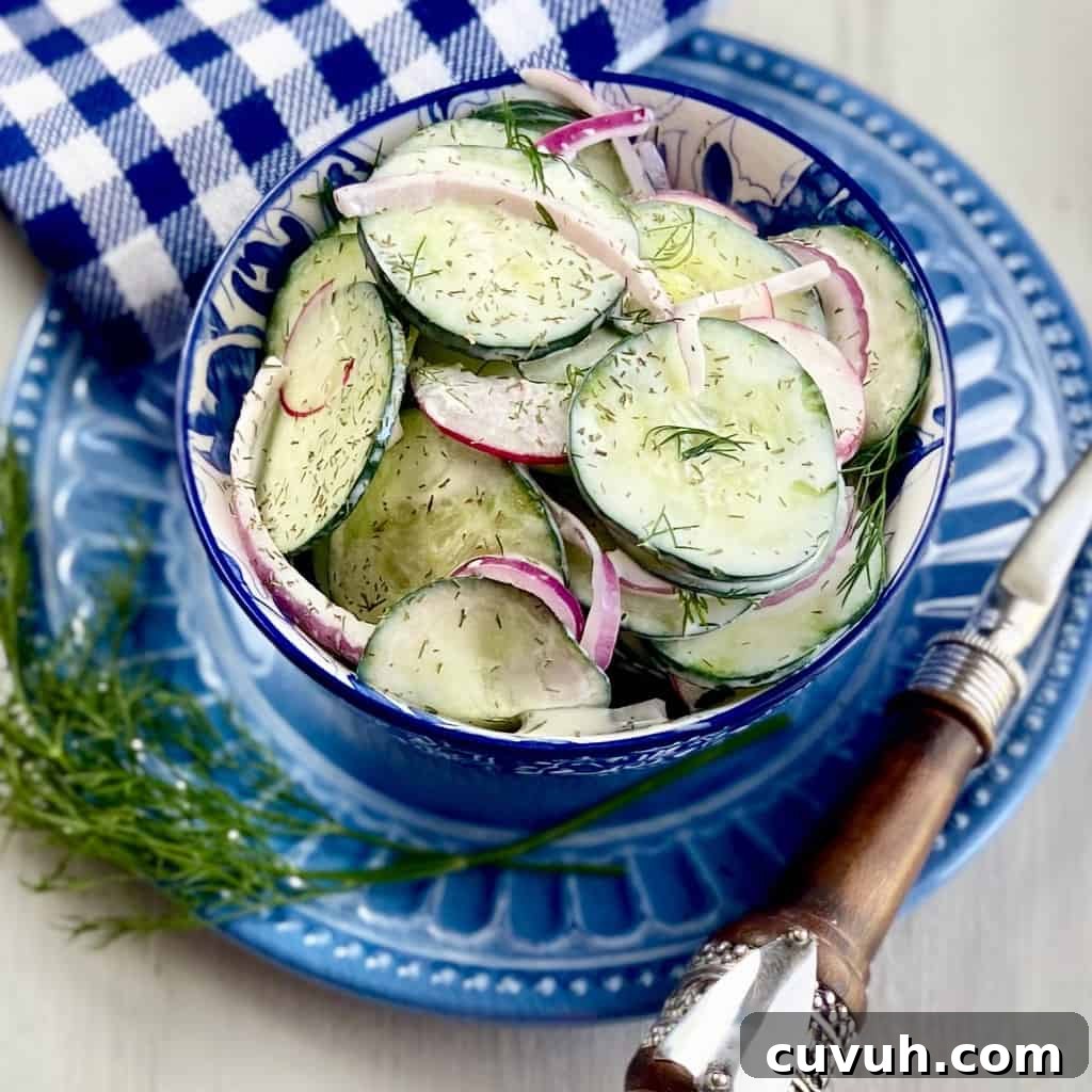 Creamy cucumber salad in a blue and white bowl.