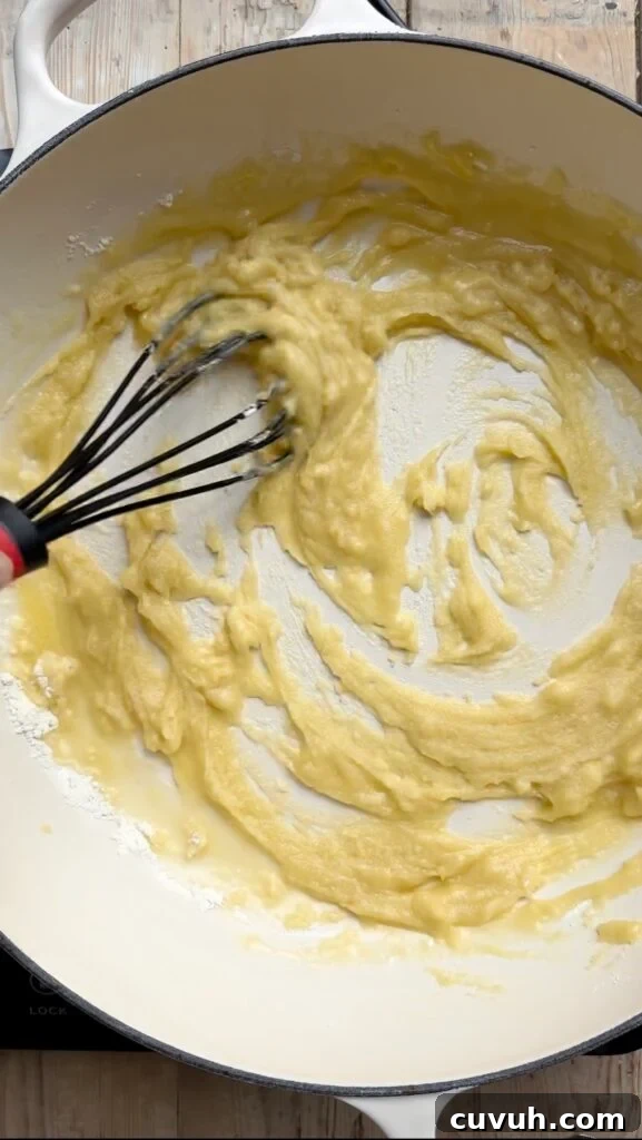 Creamy Baked Macaroni and Cheese Casserole 5 Flour and butter roux being stirred in a pan.