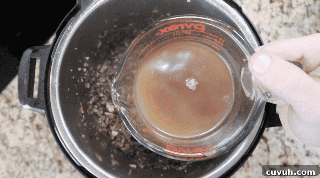 Adding beef broth to the pot