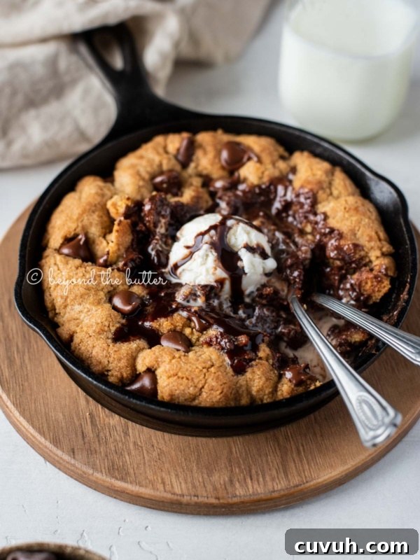 Warm chocolate chip skillet cookie with scoop of vanilla ice cream