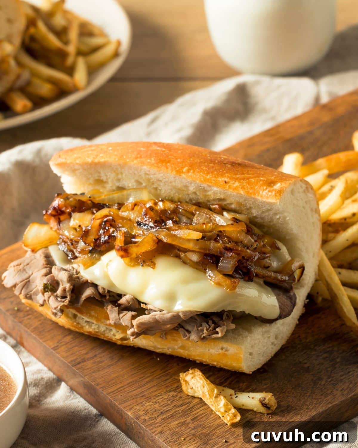 Slow-Cooker French Dip Sandwich Recipe with Juicy Beef and Au Jus 2 A slow cooker French Dip sandwich topped with grilled onions.