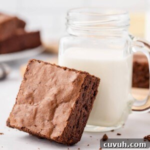 Brown Butter Brownie resting against a mason jar of milk