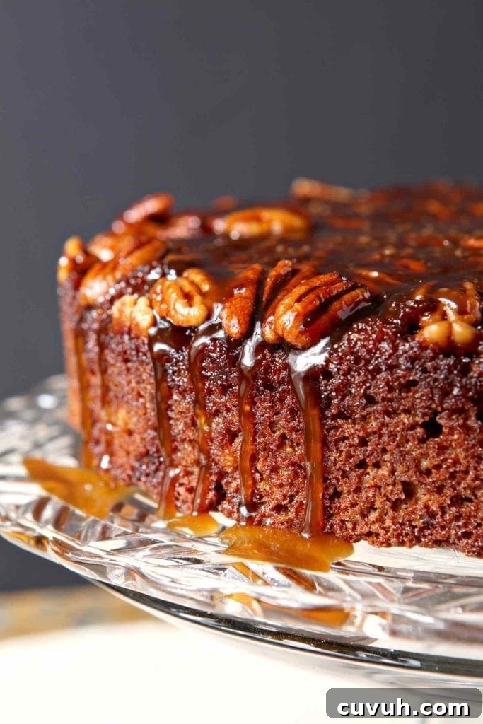 The topping drips down the side of a Praline Pumpkin Upside Down Cake before serving