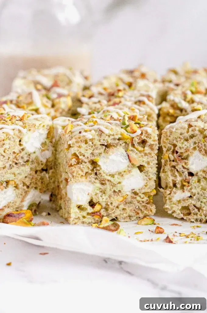 Light green pistachio rice krispie treats full of bright white marshmallows and chopped up pistachios.