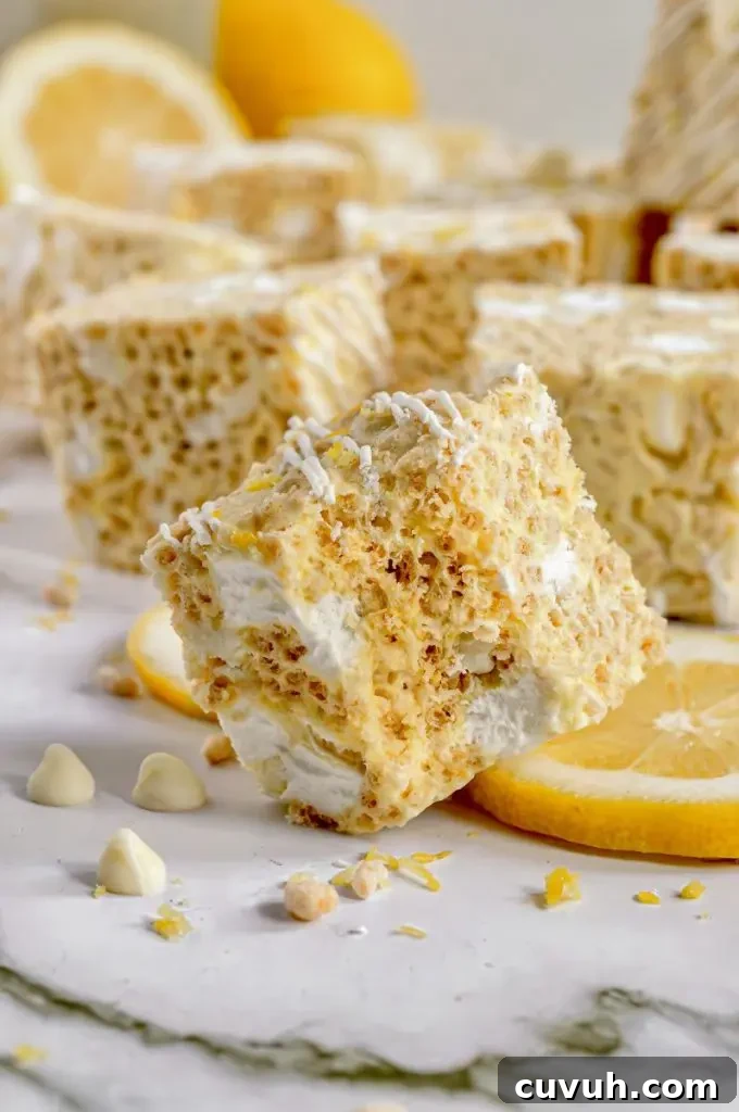 Bright yellow lemon rice krispie treats with bright white marshmallows and white chocolate drizzled on top.