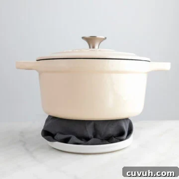 Sticky Teriyaki Tofu Bowl with Sesame and Scallions 13 Tofu wrapped in a clean towel on a plate with a pot on top.