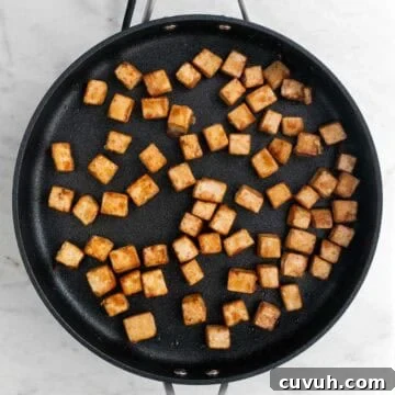 Sticky Teriyaki Tofu Bowl with Sesame and Scallions 16 Sautéed tofu cubes in a skillet.