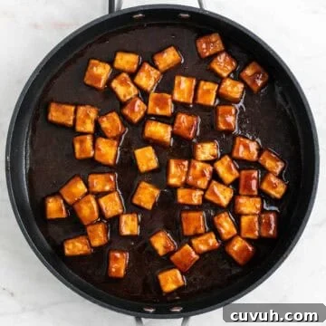 Sticky Teriyaki Tofu Bowl with Sesame and Scallions 18 Teriyaki tofu in a pan.