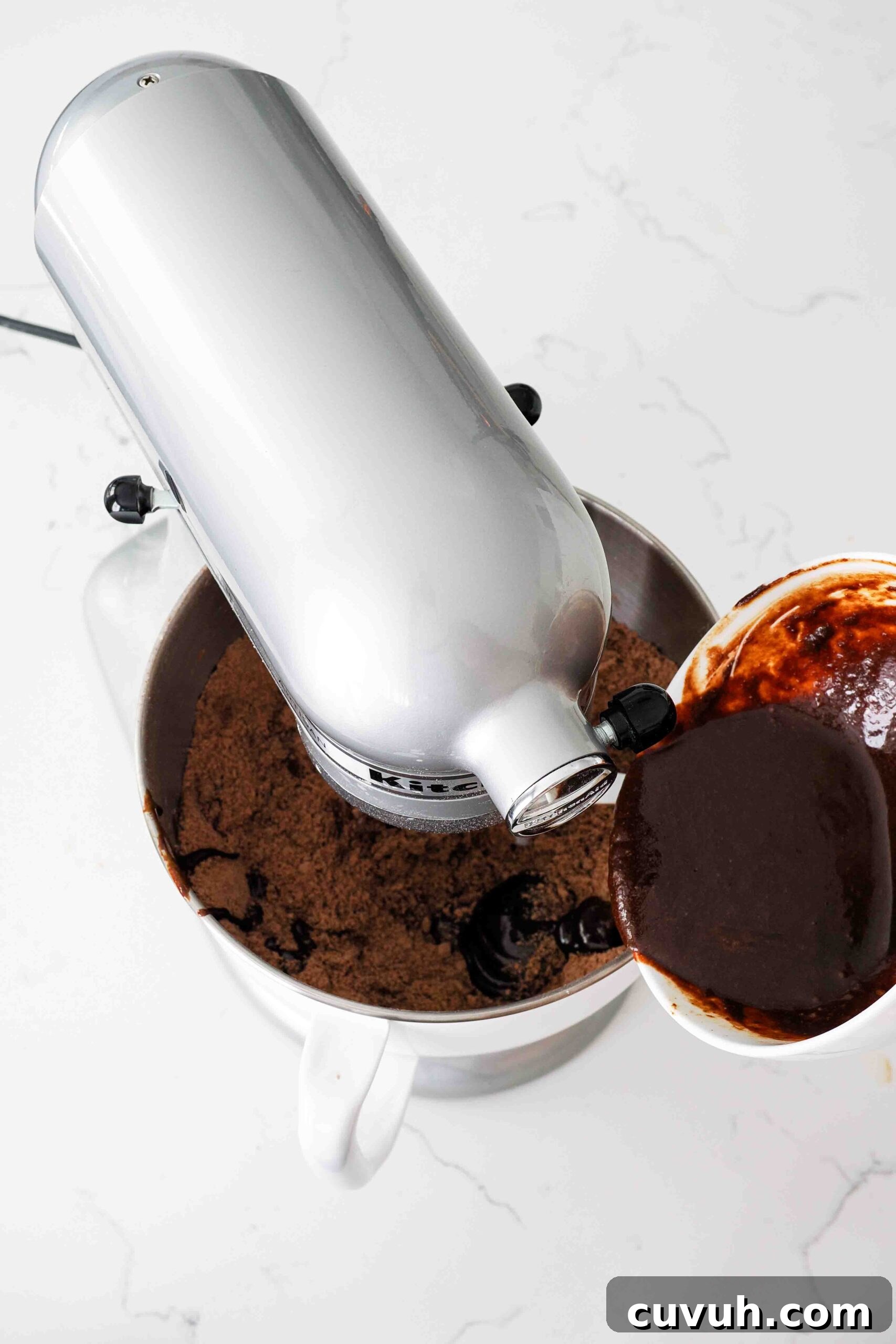 Chocolate Gingerbread Cookies with Cocoa and Warm Spices 5 Dark liquid is poured into the bowl of a stand mixer with cocoa-colored dough.