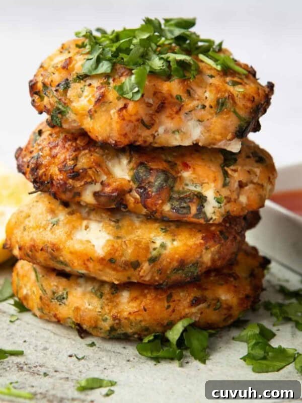 Sweet Chilli Salmon Fishcakes stacked on top of each other, topped with coriander