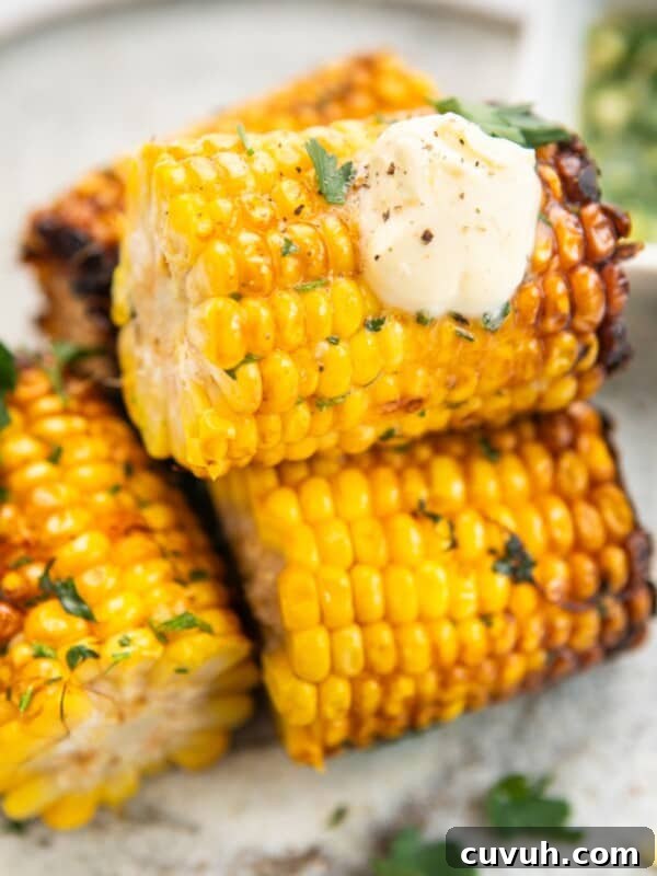 Air fryer corn on the cob served with cream on top.