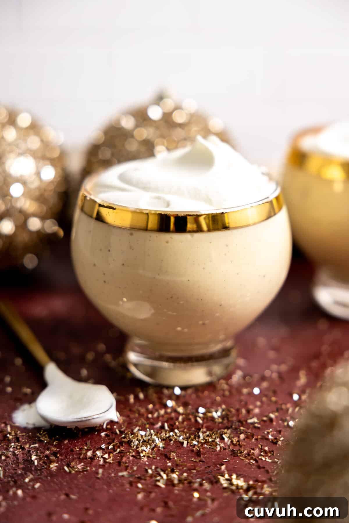 Glass of eggnog topped with whipped cream.