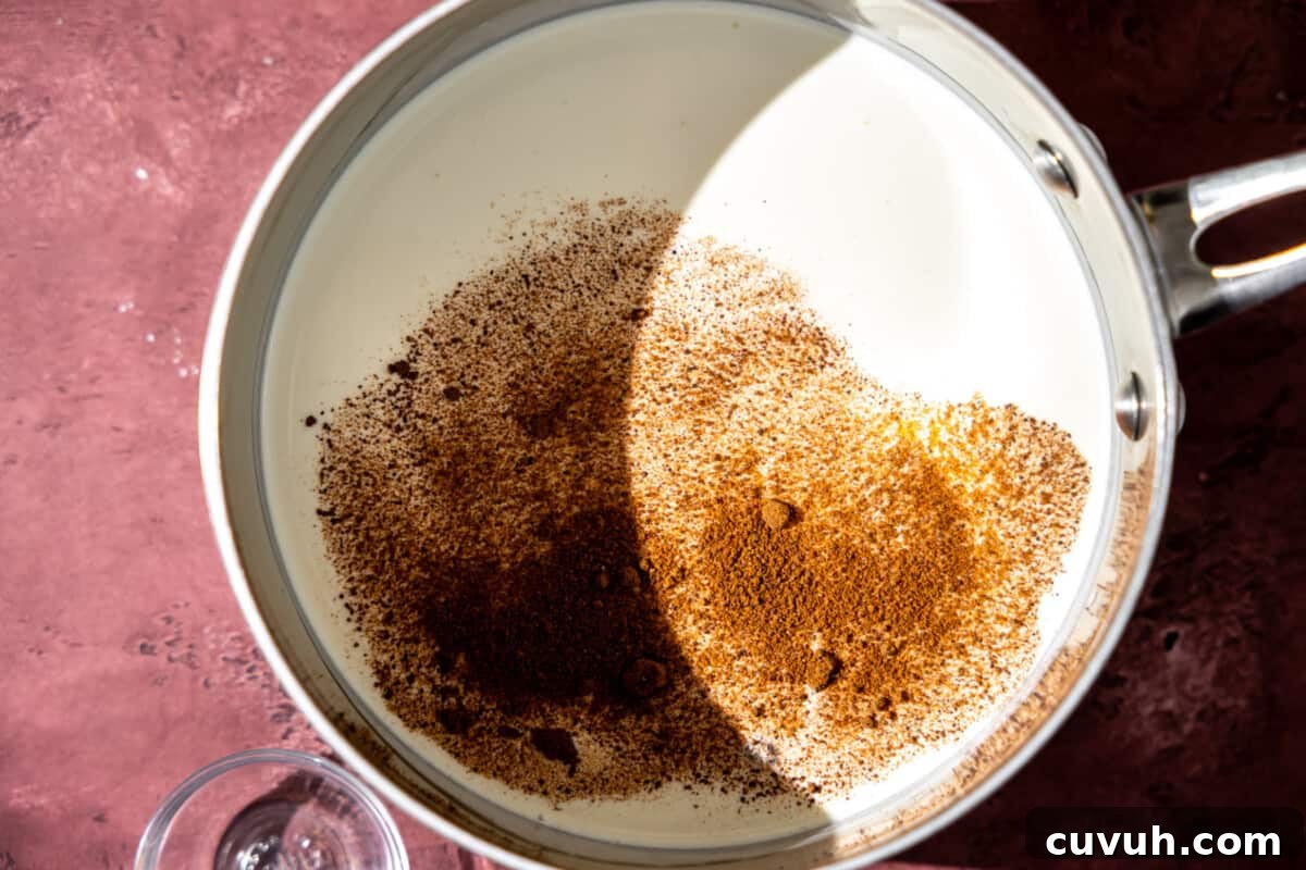 Milk, cream and nutmeg in a saucepan.