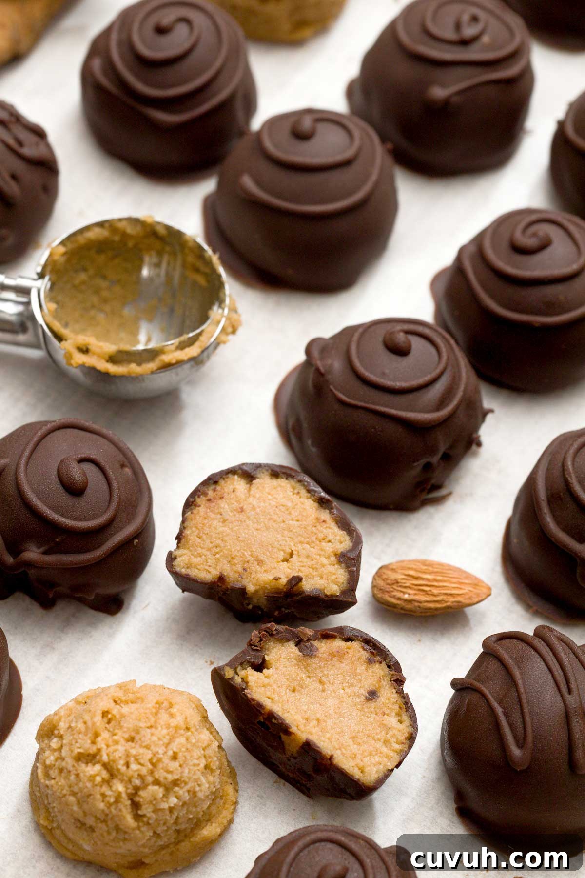 A batch of chocolate pumpkin truffles dipped in chocolate with swirls on top.