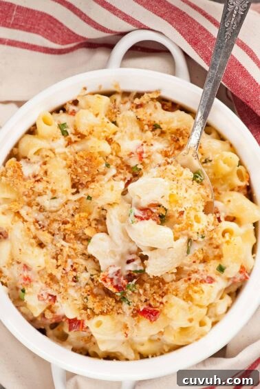 Goat cheese and sun-dried tomato mac and cheese with garlic breadcrumb topping in a white baking dish.
