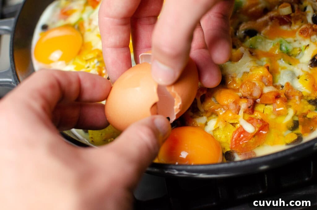 Brunch Nachos: Loaded Breakfast Nachos with Eggs & Avocado 9 Cracking an egg by hands open to place onto our breakfast brunch nachos