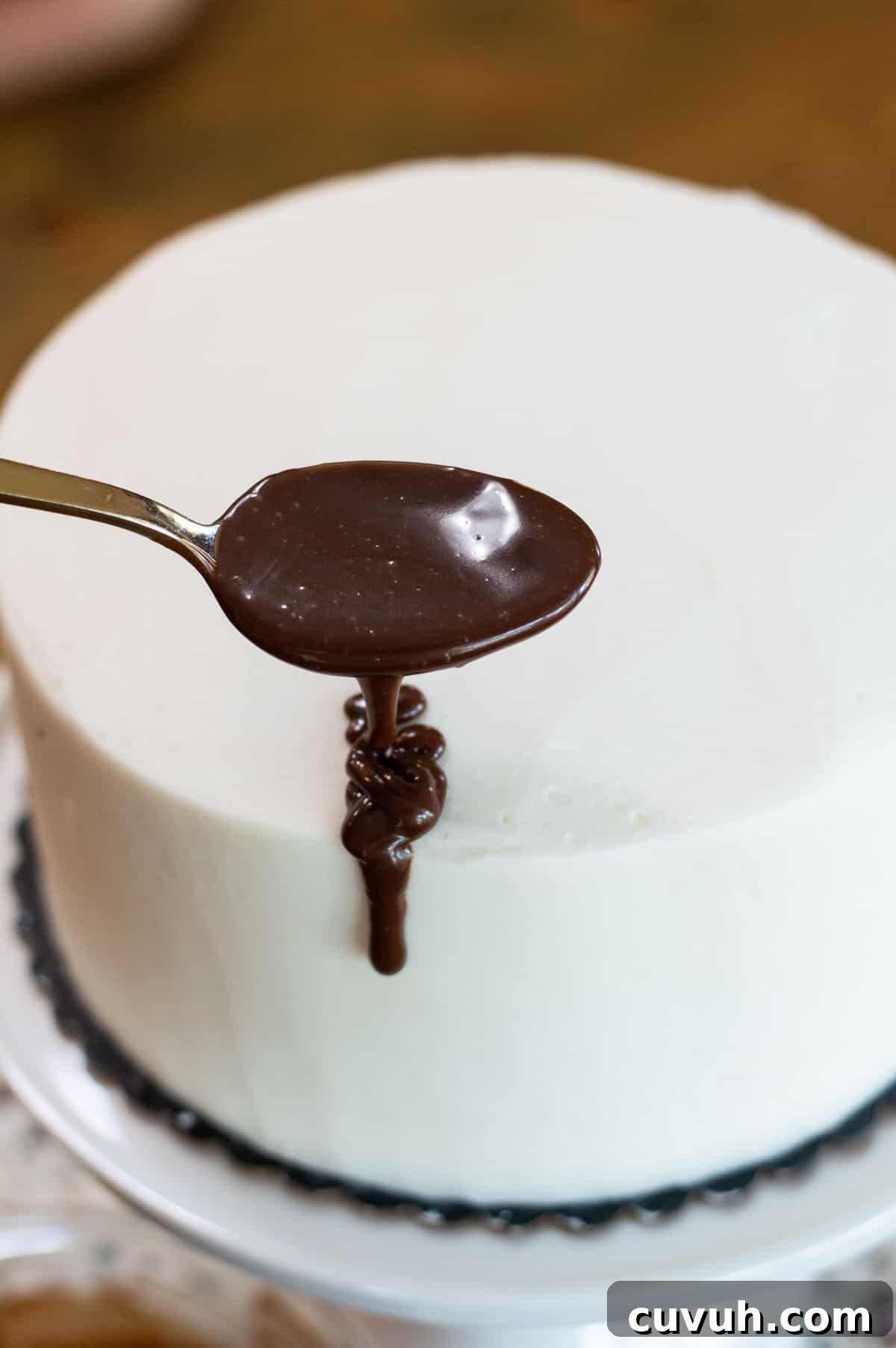 White frosted drip cake with chocolate ganache