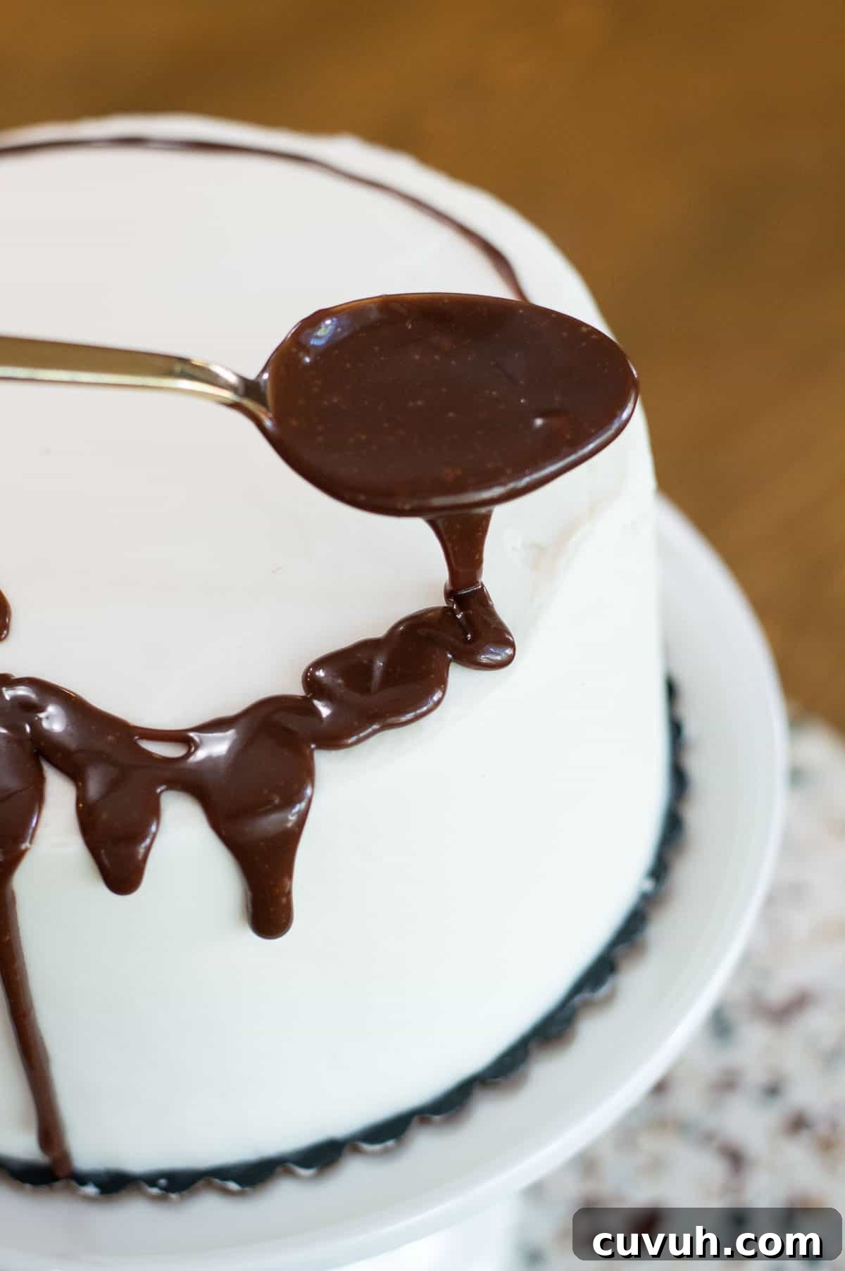 White frosted drip cake with chocolate ganache