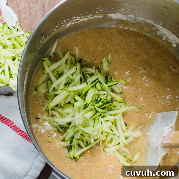 Moist Zucchini Bread Recipe with Brown Sugar and Cinnamon 5 Adding grated zucchini to the batter.