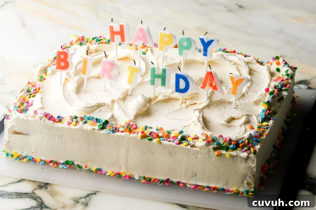Party-Size Vanilla Birthday Sheet Cake Recipe 2 cake fully frosted and decorated with 'happy birthday' rainbow candles and confetti sprinkles - horizontal