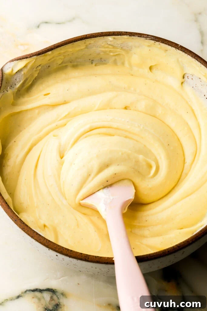Party-Size Vanilla Birthday Sheet Cake Recipe 22 pastry cream with whipped cream folded in, in a bowl with a spatula