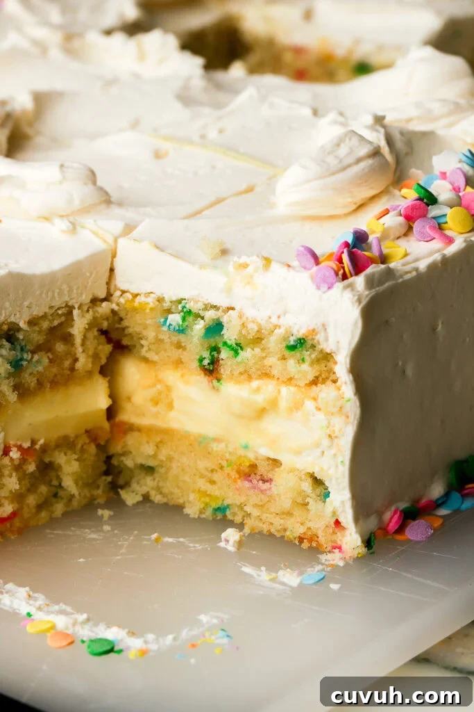 Party-Size Vanilla Birthday Sheet Cake Recipe 4 close up of a slice of vanilla cake with custard filling and sprinkles, sliced on the cutting board, corner piece