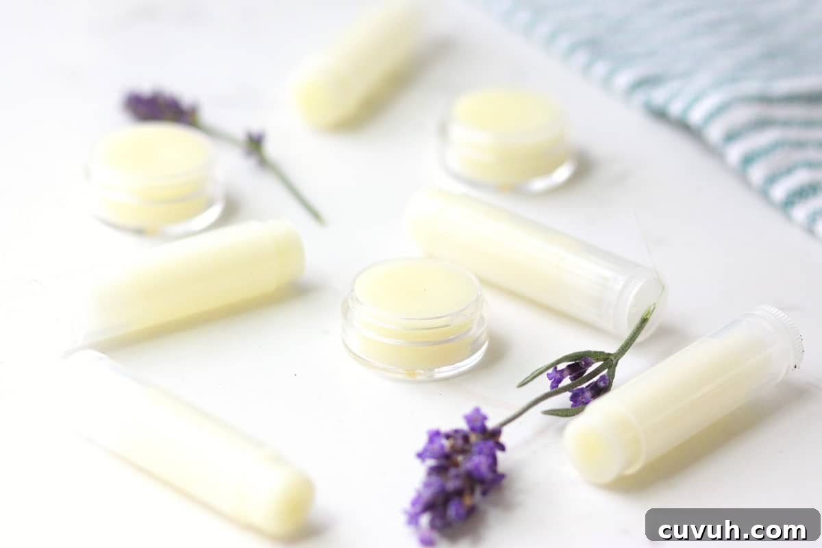 a variety of beeswax lip balms laying on a white table surrounded by lavender flowers
