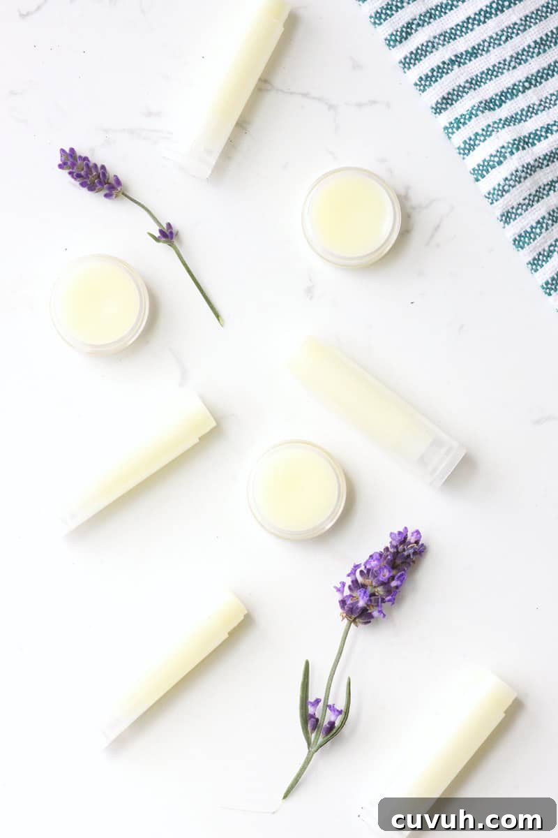 a variety of beeswax lip balms laying on a white table surrounded by lavender flowers
