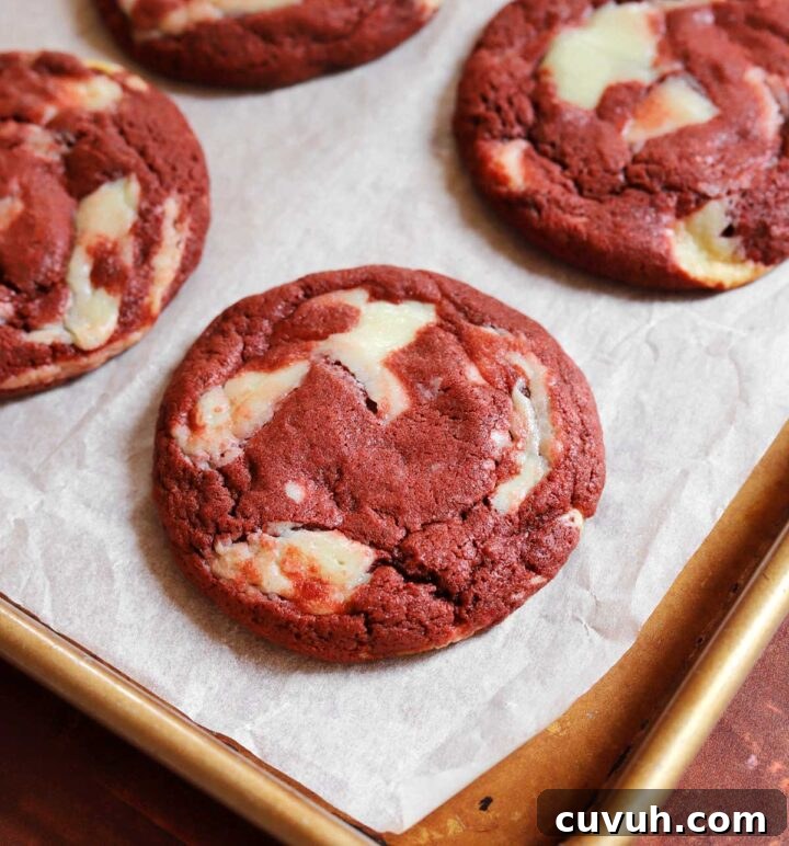 Decadent Red Velvet Cookies Recipe for Perfect Soft-Chewy Treats 3 red velvet cookies on parchment-lined baking sheet