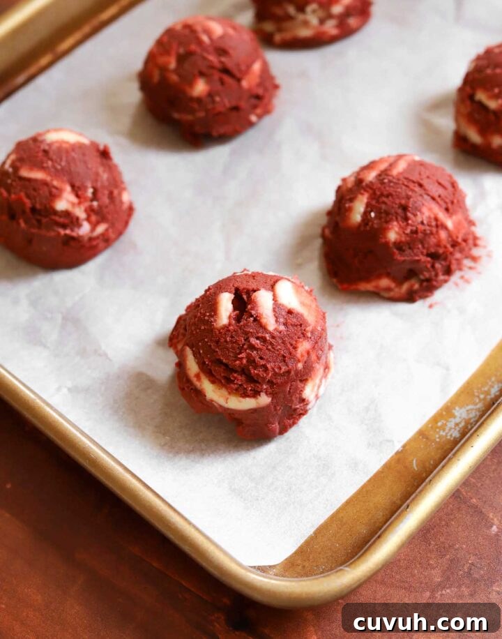 Decadent Red Velvet Cookies Recipe for Perfect Soft-Chewy Treats 6 red velvet cookie dough on parchment lined baking sheet before baking
