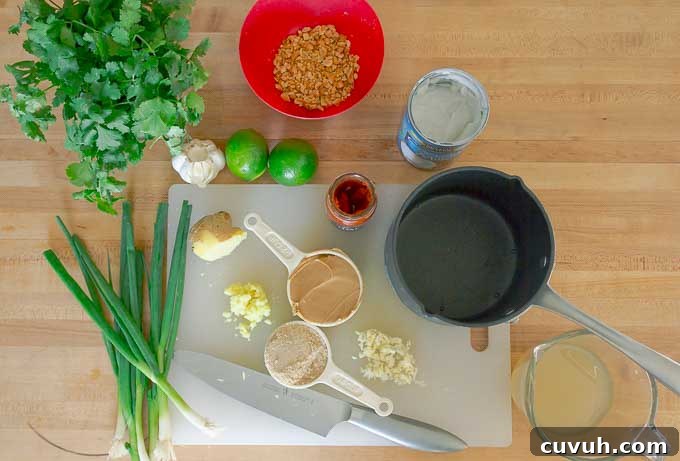 Thai Peanut Sauce Recipe ingrediantsbeing prepped an dmeasured on white cutting board
