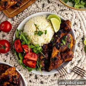 Honey Chipotle Glazed Chicken Thighs Recipe 11 honey chipotle chicken thighs with rice and tomatoes on a plate.