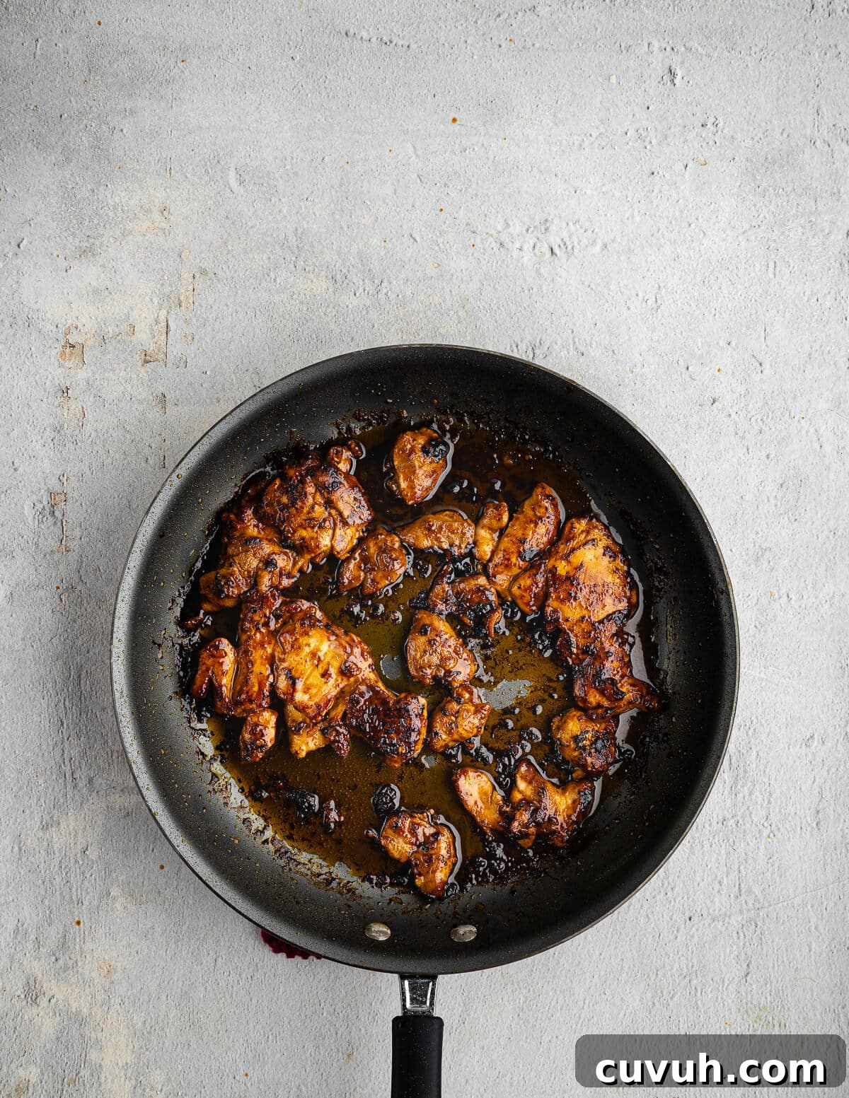 Honey Chipotle Glazed Chicken Thighs Recipe 8 caramelized chipotle honey chicken thighs in a skillet.