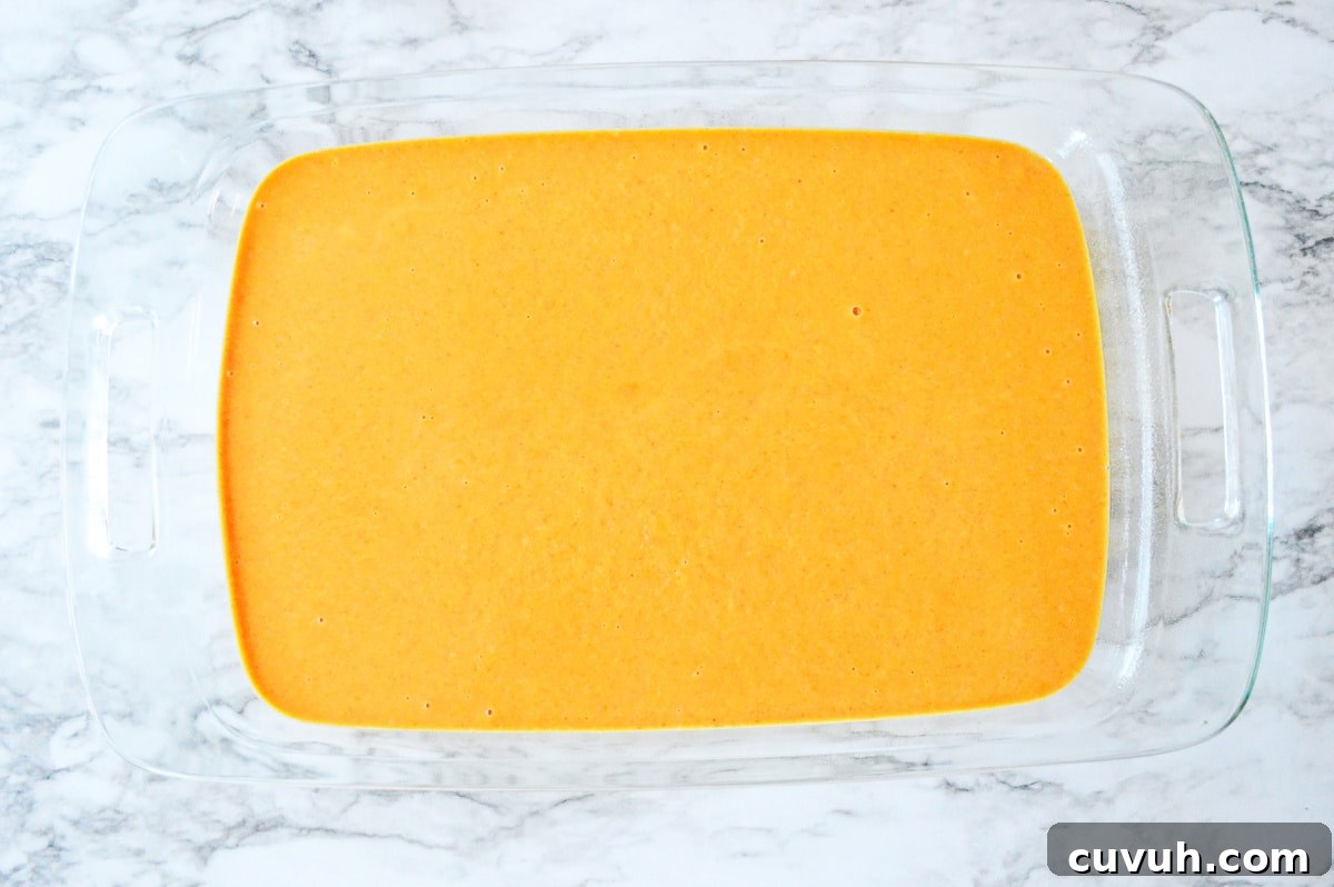 pumpkin layer spread on top of cake batter in glass baking pan