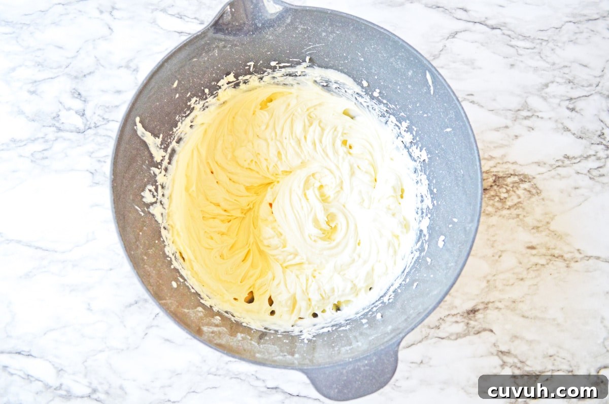 whipped cream cheese frosting in gray mixing bowl