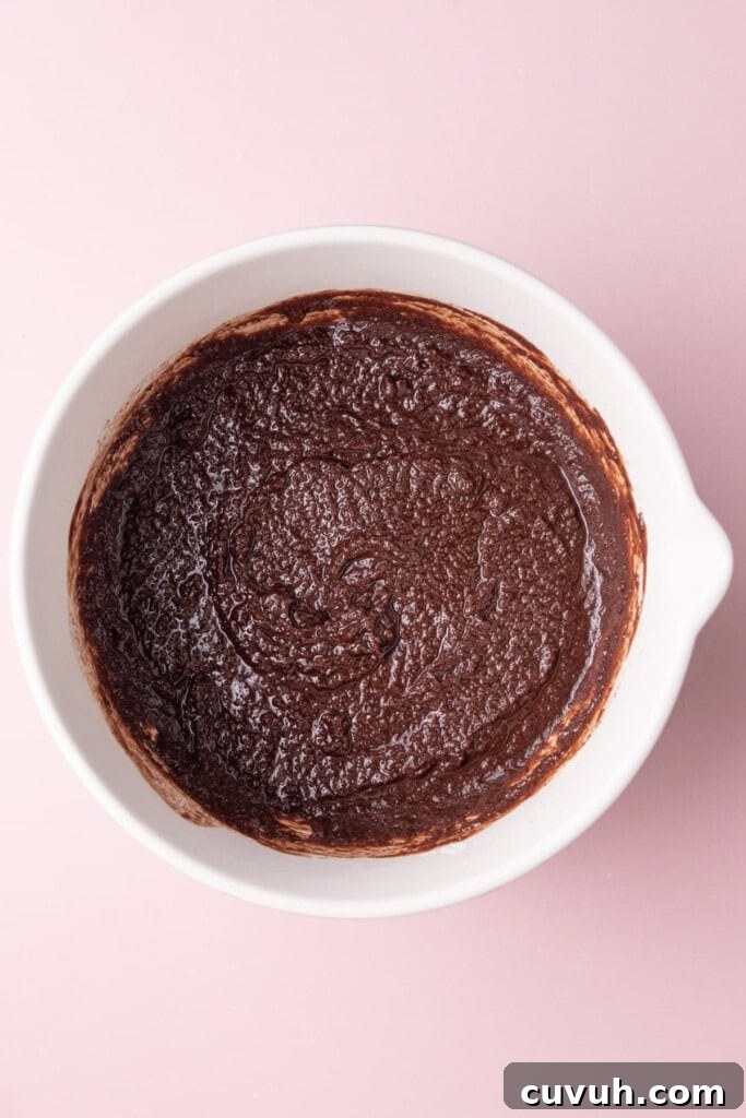 Melted chocolate, melted butter, and sugar whisked together in a large mixing bowl.