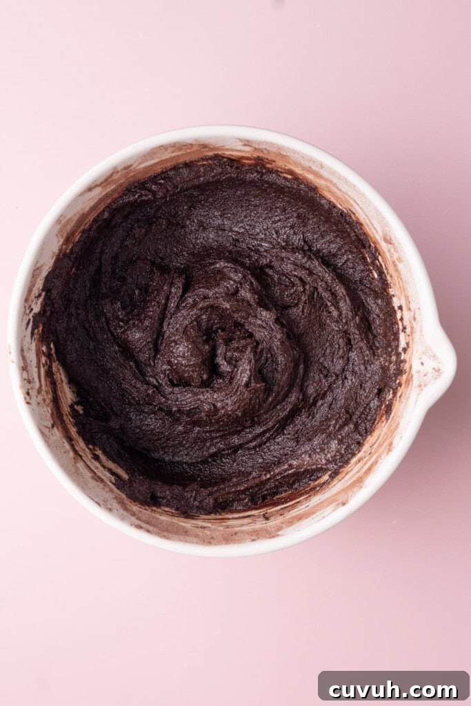 Thick brownie batter in a large mixing bowl before adding rainbow sprinkles.