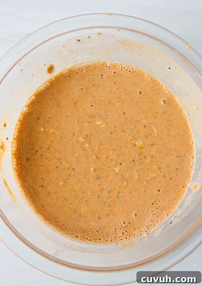 Pumpkin Protein Overnight Oats Recipe for Morning Energy 5 A clear bowl full of mixed pumpkin spice oatmeal ingredients.