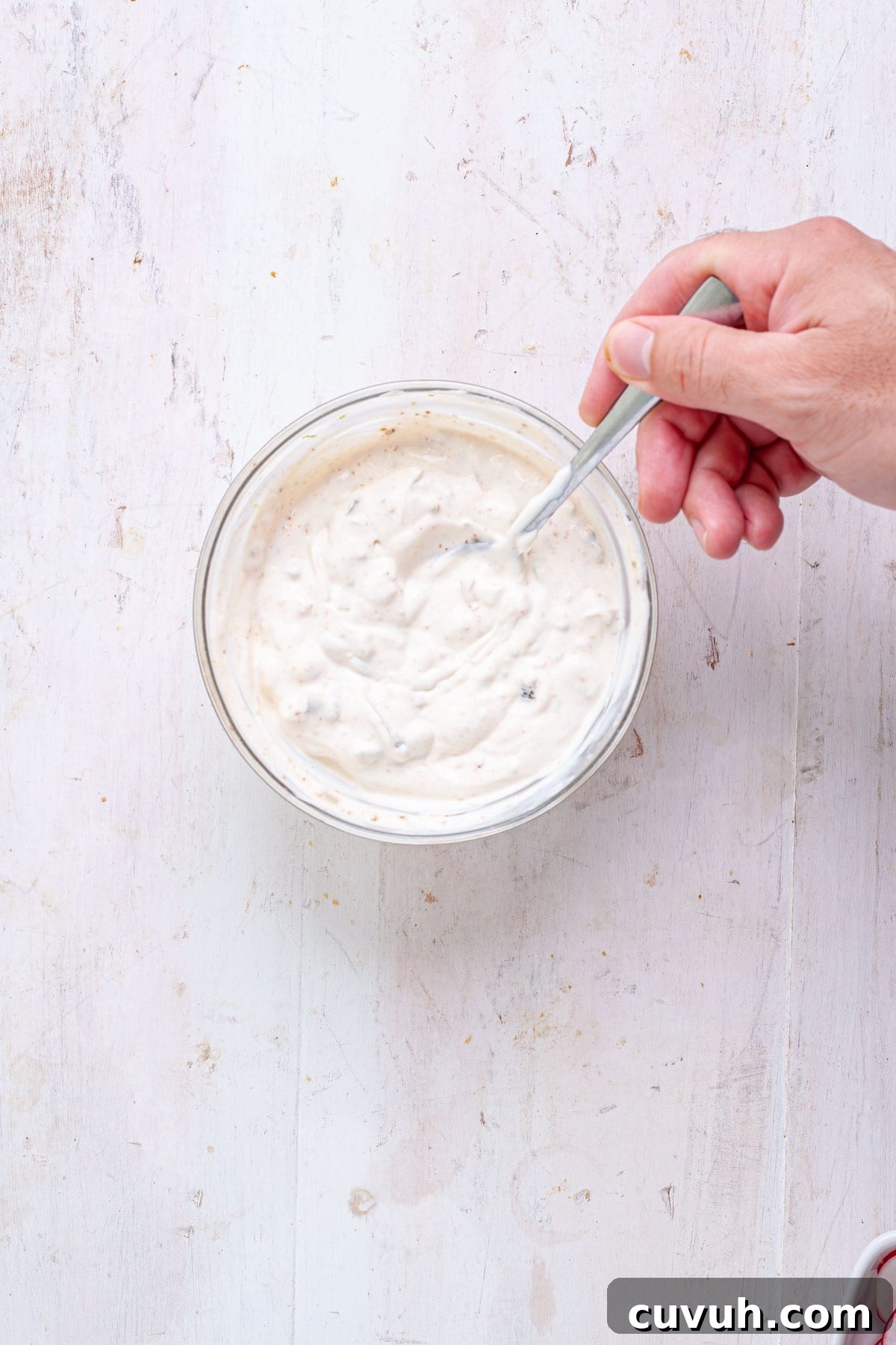 A sour cream and jalapeno sauce for chili lime shrimp tacos in a small bowl.