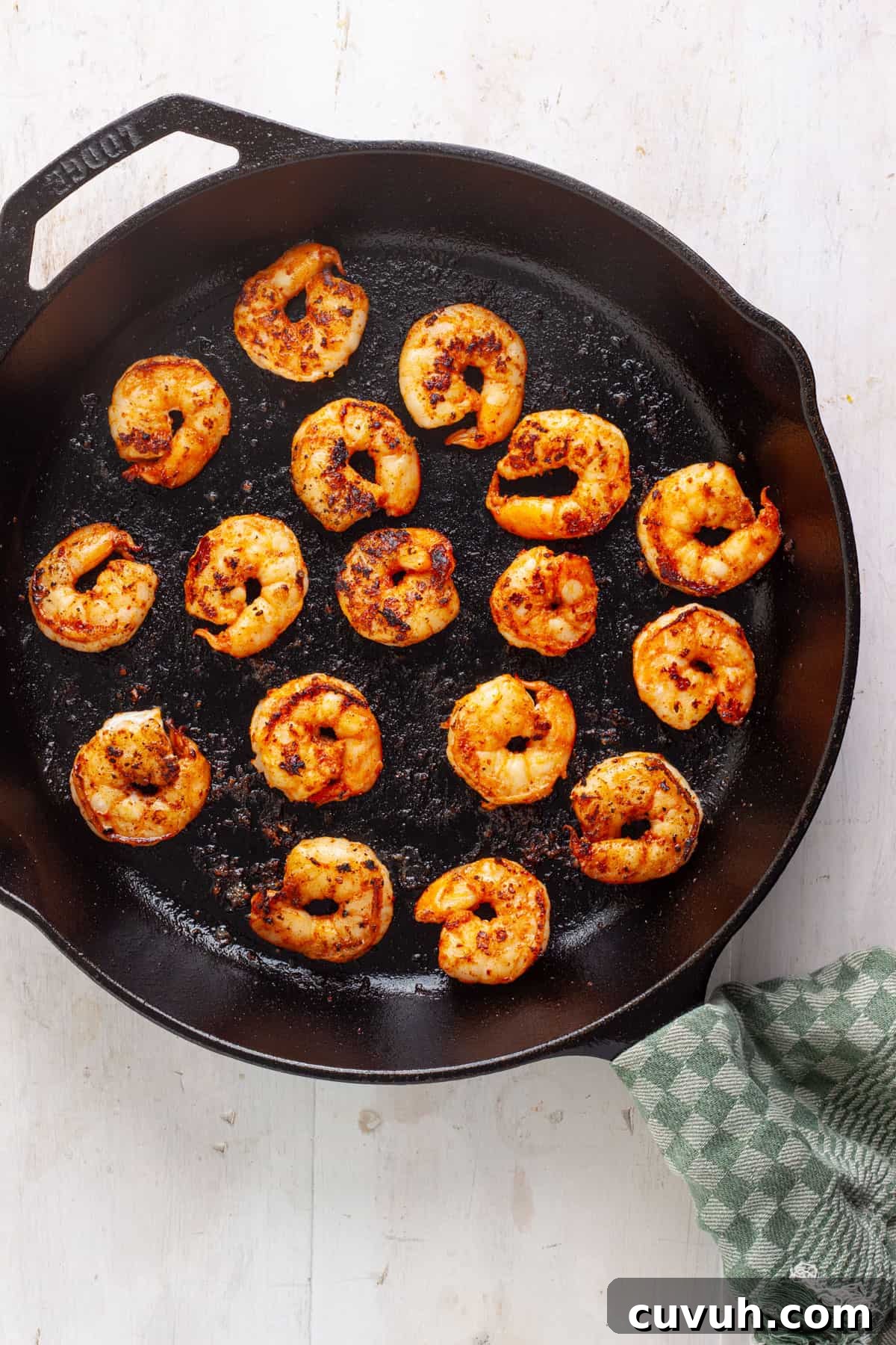 Chili lime shrimp searing in a large cast iron skillet.