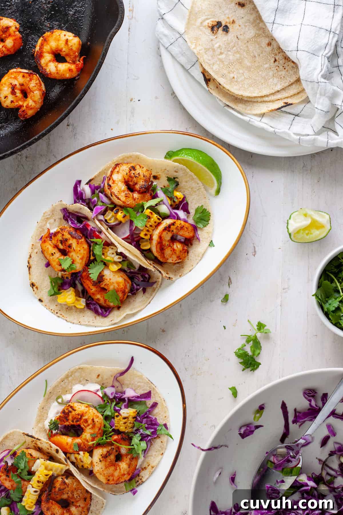 Chili lime shrimp tacos on plates with garnishes off to the side.
