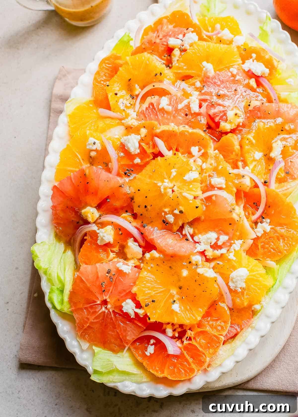 Refreshingly Zesty Citrus Salad Recipe with Honey-Lime Dressing 2 Citrus salad with feta and onions on a white platter.