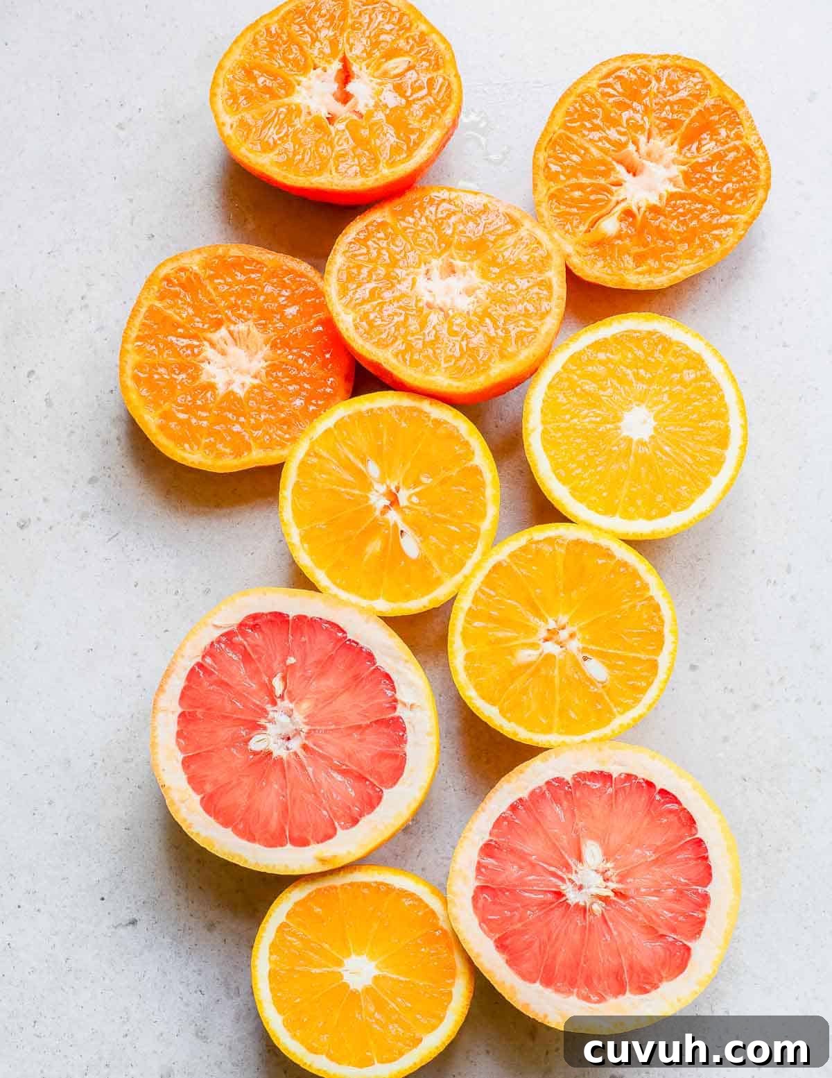 Refreshingly Zesty Citrus Salad Recipe with Honey-Lime Dressing 4 Sliced oranges and grapefruits on a white surface.